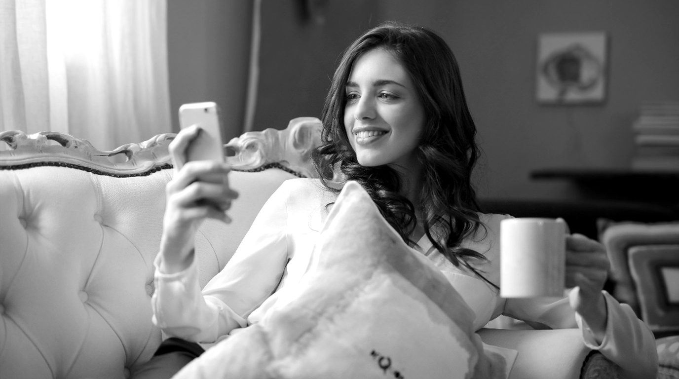 A buyer viewing a new condo building on her phone at home